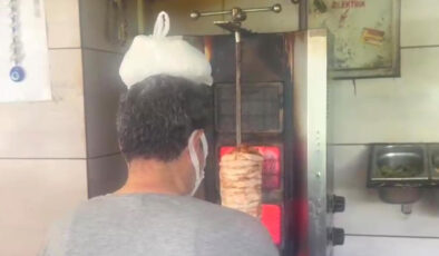 Hatay’da sıcaktan bunalan dönerci ustası kafasına buz torbası koydu