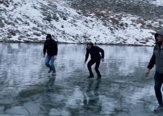 Artvinli gençler buz tutan Karagöl’de buz kalınlığını taşla test edip eğlendi